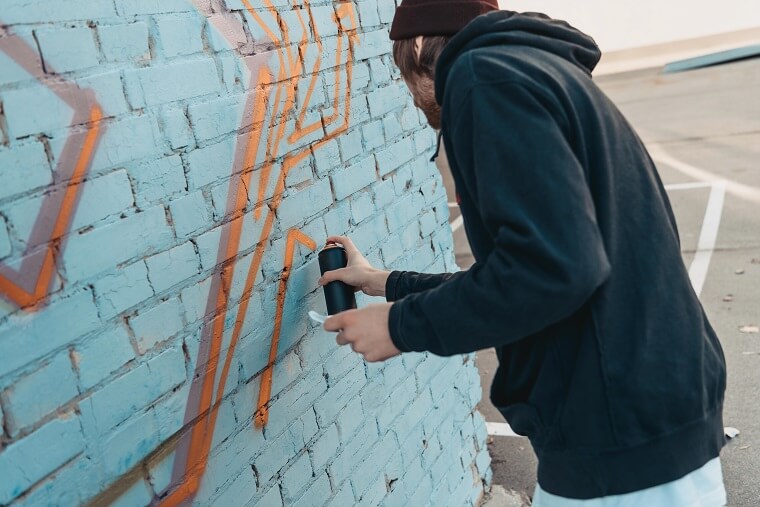 Graffiti aanbrengen op blauwe muur